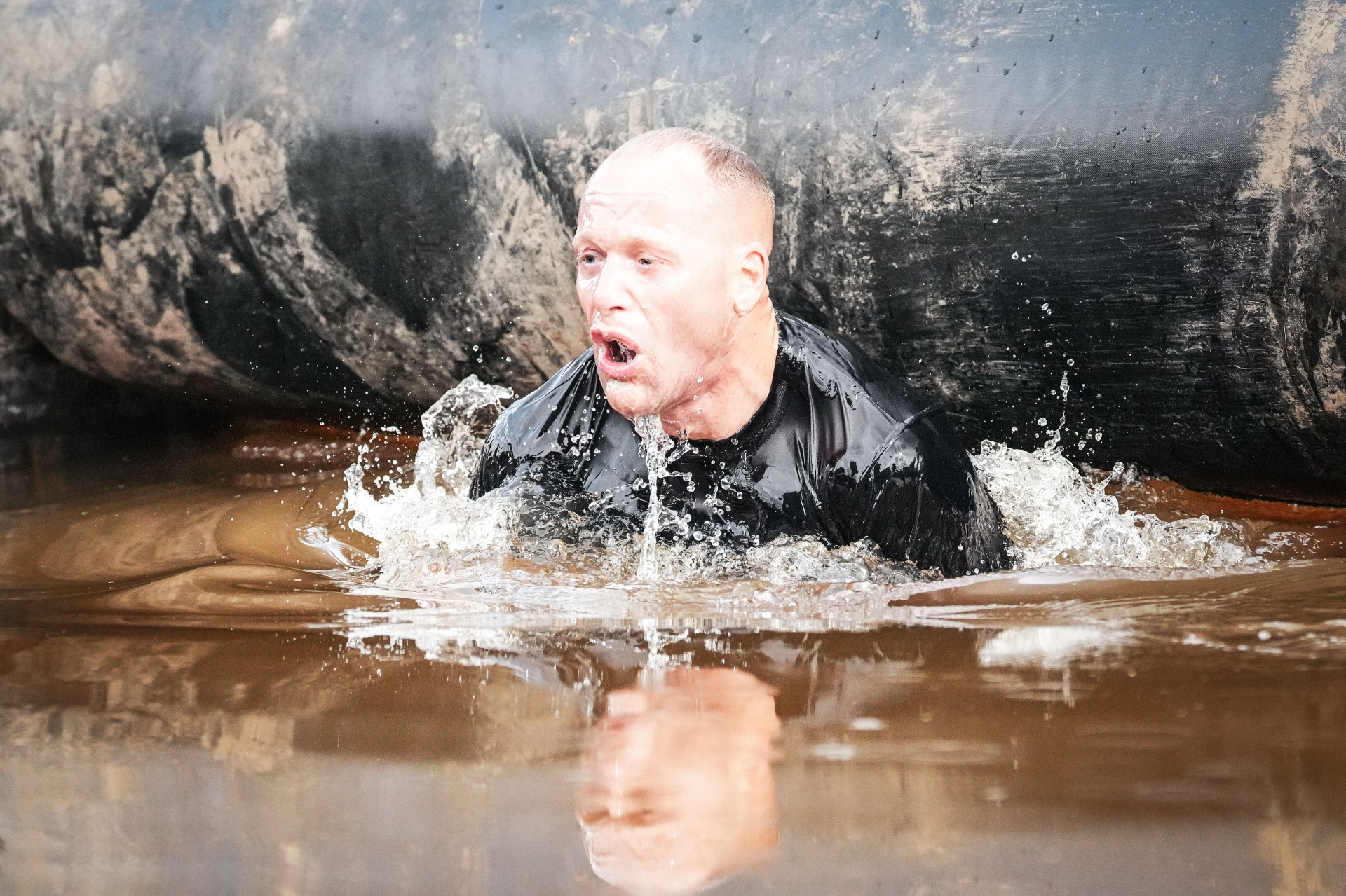 Niklas Lindahl emerging from water at a Mud Master obstacle race